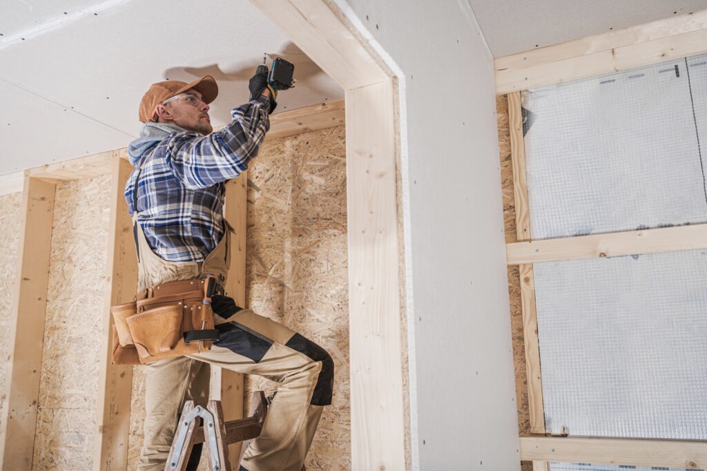 General Construction Contractor Worker Attaching Drywall Using Drill Driver